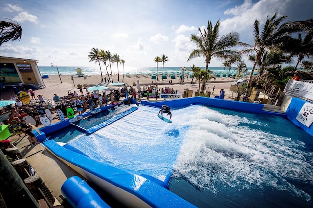 view of pool with a water view and a view of the beach