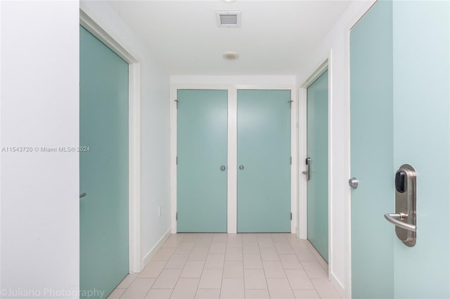 hall featuring light tile flooring