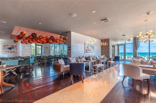 interior space featuring dark hardwood / wood-style floors, an inviting chandelier, and a water view