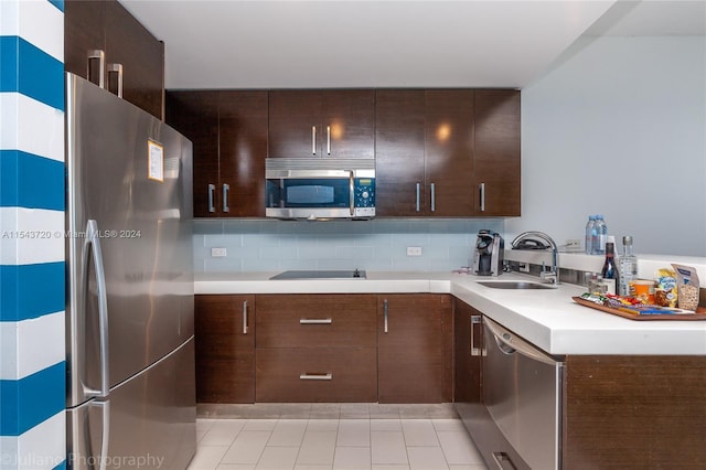 kitchen featuring tasteful backsplash, stainless steel appliances, light tile floors, and sink