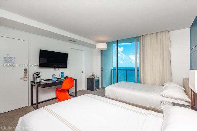 bedroom featuring access to outside, floor to ceiling windows, and carpet