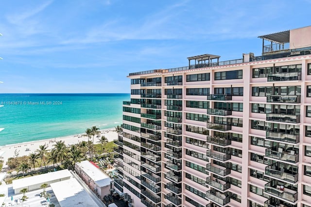 view of building exterior with a water view and a beach view