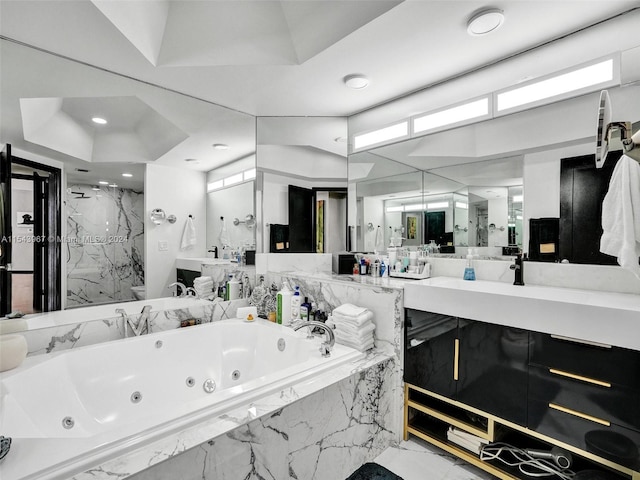 bathroom featuring tiled bath, vanity, and tile flooring