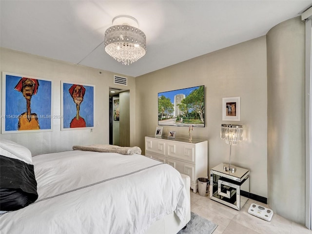 bedroom featuring an inviting chandelier and light tile floors