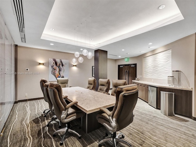 carpeted dining space with a raised ceiling