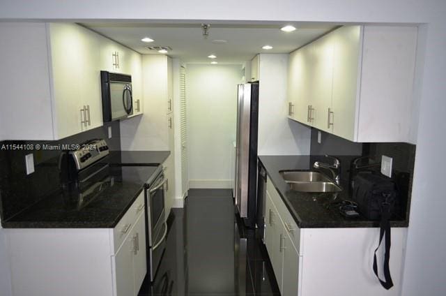 kitchen featuring white cabinets, double oven range, and sink