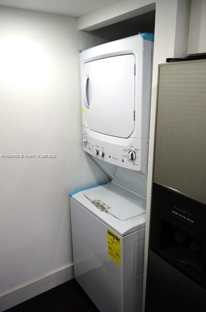 clothes washing area featuring stacked washer and dryer