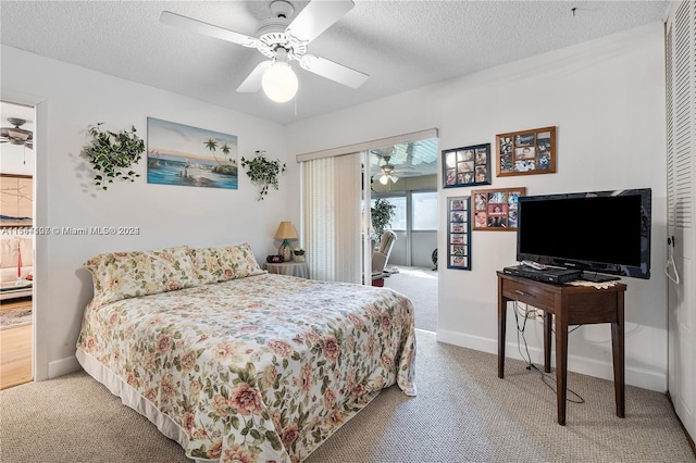 carpeted bedroom featuring ceiling fan and a textured ceiling