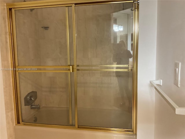 bathroom featuring combined bath / shower with glass door