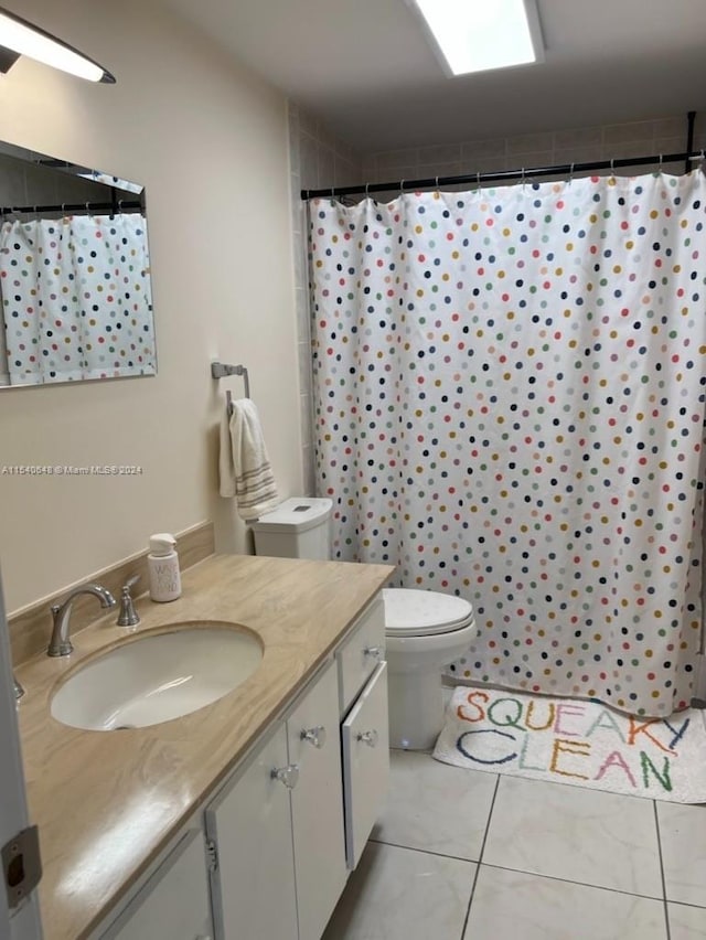 bathroom with toilet, tile flooring, and vanity