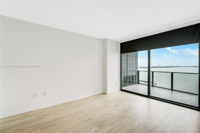 spare room with light hardwood / wood-style flooring and a wall of windows