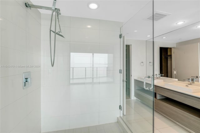 bathroom with a shower with shower door, vanity, and tile patterned flooring