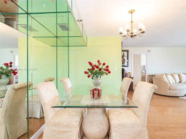 dining area featuring an inviting chandelier and light hardwood / wood-style flooring