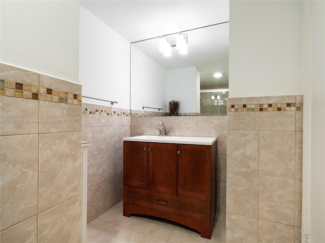 bathroom featuring tile patterned flooring, vanity, and tile walls