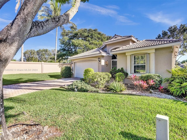 view of front of house featuring a garage and a front lawn