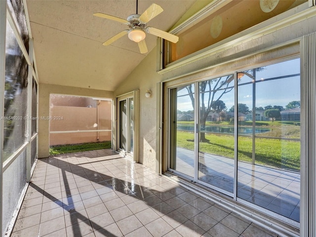 unfurnished sunroom with ceiling fan, a water view, and vaulted ceiling