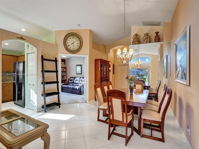 dining room with light tile patterned floors, high vaulted ceiling, and a notable chandelier