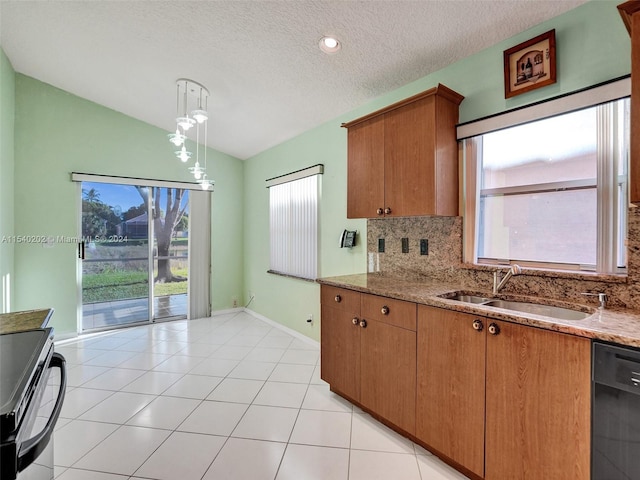 kitchen with backsplash, sink, pendant lighting, black dishwasher, and lofted ceiling