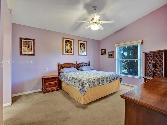 carpeted bedroom with ceiling fan and vaulted ceiling