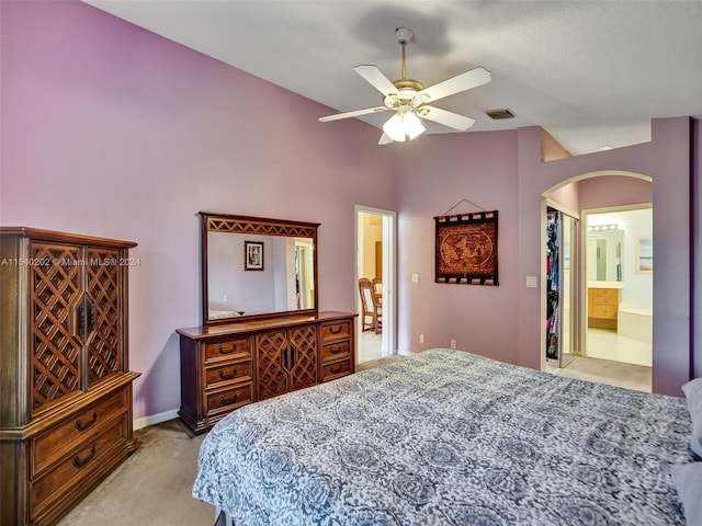 carpeted bedroom with ensuite bathroom, a closet, ceiling fan, and a high ceiling