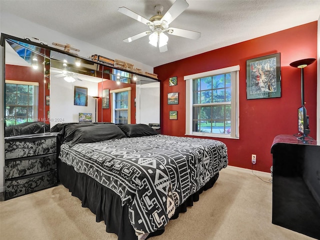 bedroom featuring carpet flooring, ceiling fan, and a textured ceiling