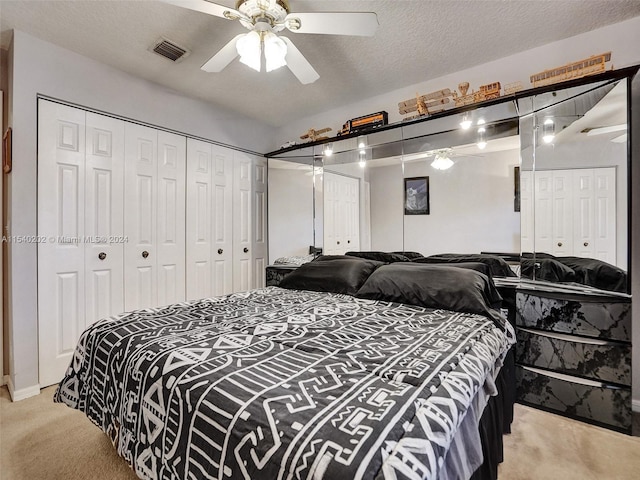 bedroom with light carpet, ceiling fan, and a textured ceiling