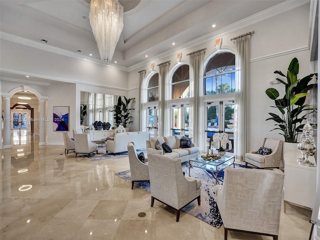 living room with a notable chandelier, crown molding, a high ceiling, and french doors