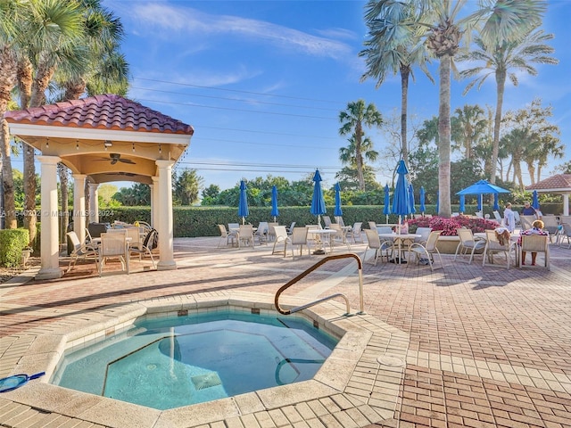 view of pool featuring a hot tub, ceiling fan, and a patio area