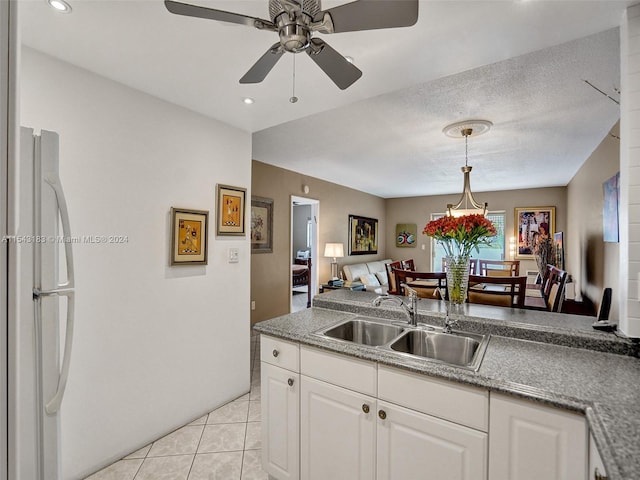 kitchen with white fridge, ceiling fan, sink, light tile floors, and white cabinets