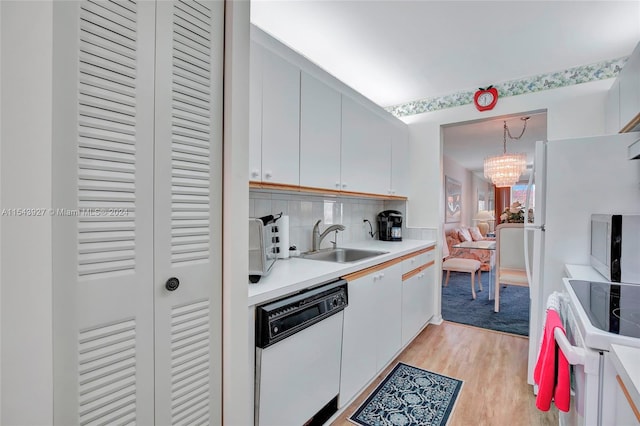 kitchen featuring white appliances, an inviting chandelier, sink, tasteful backsplash, and light hardwood / wood-style floors