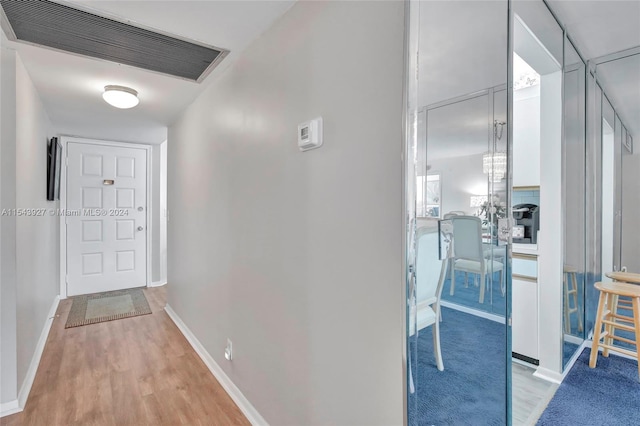 corridor with light hardwood / wood-style floors