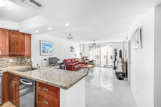 kitchen featuring light stone counters, sink, kitchen peninsula, and ceiling fan