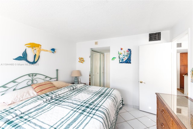 tiled bedroom featuring a textured ceiling