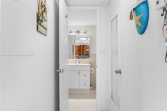 345 Ocean Dr Unit 411, Miami Beach, FL 33139 - corridor with light tile patterned floors and tile walls