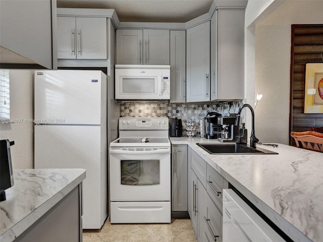 kitchen featuring gray cabinetry, tasteful backsplash, white appliances, and sink