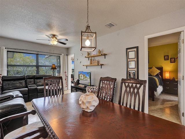 dining room featuring light tile floors, a textured ceiling, and ceiling fan