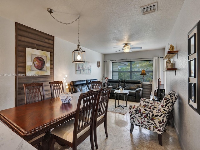 tiled dining room featuring ceiling fan and a textured ceiling