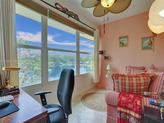 tiled home office featuring a water view, ceiling fan, and a wealth of natural light