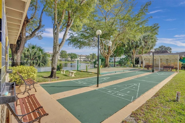 view of property's community with a lawn and a water view