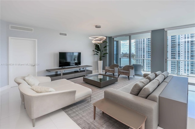 living room with light tile floors, a wall of windows, and a chandelier