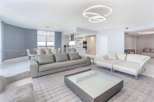 carpeted living room featuring an inviting chandelier