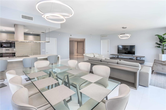 tiled dining space featuring an inviting chandelier