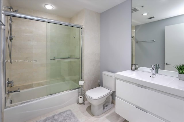 full bathroom with tile floors, toilet, bath / shower combo with glass door, and vanity