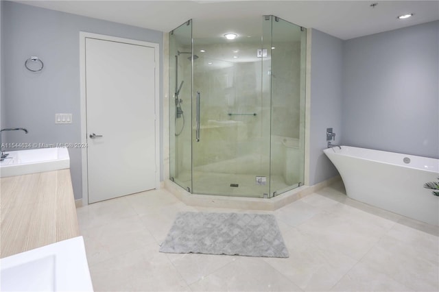 bathroom featuring independent shower and bath, tile flooring, and sink