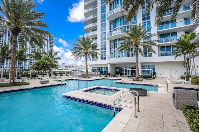 view of pool with a community hot tub and a patio area