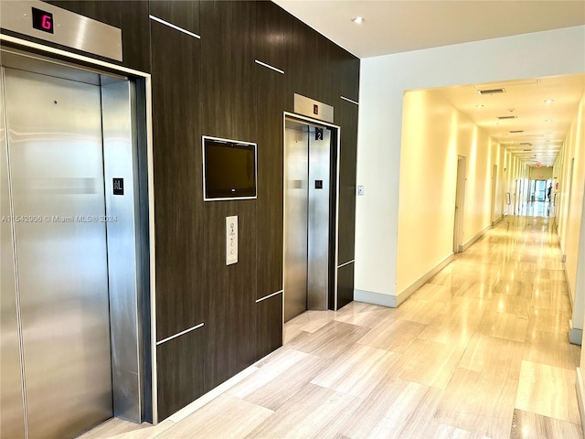 hall with elevator and light wood-type flooring