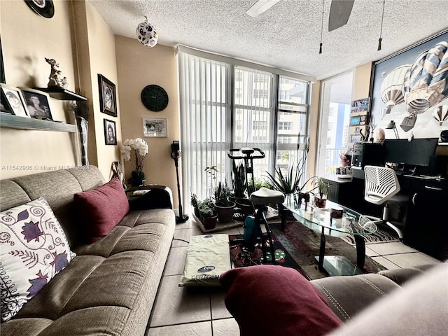 living room with a textured ceiling, light tile patterned flooring, expansive windows, and ceiling fan