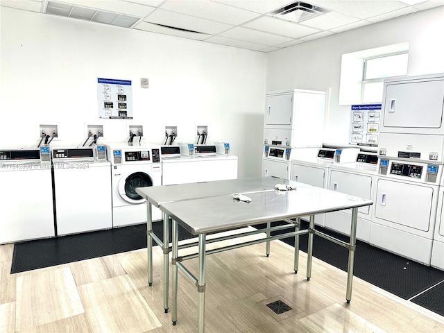 kitchen featuring light hardwood / wood-style flooring, white cabinetry, a paneled ceiling, separate washer and dryer, and stacked washer / drying machine