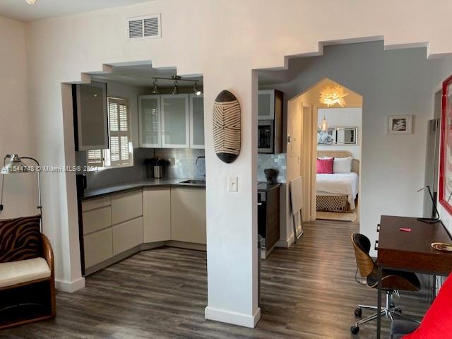 kitchen featuring sink, tasteful backsplash, and dark hardwood / wood-style flooring