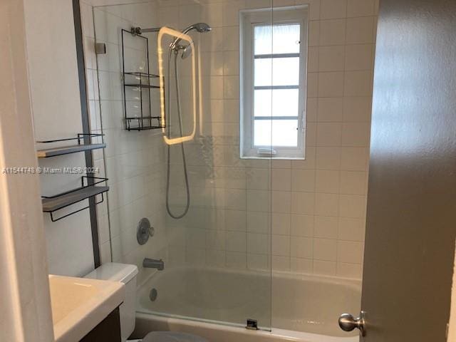 full bathroom with toilet, vanity, and tiled shower / bath